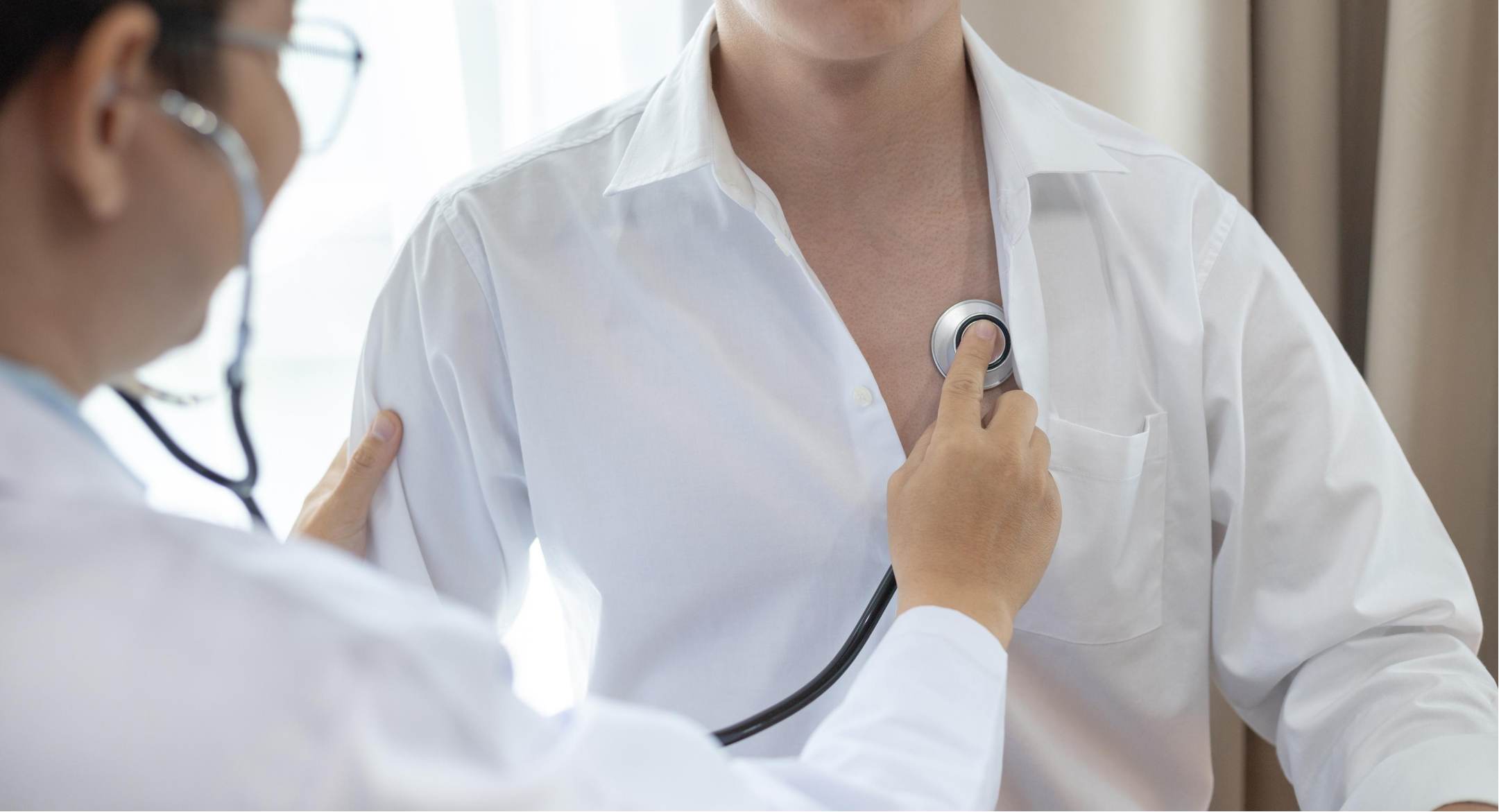 Image of woman having a doctor examine her heart rate, using a stethoscope. 