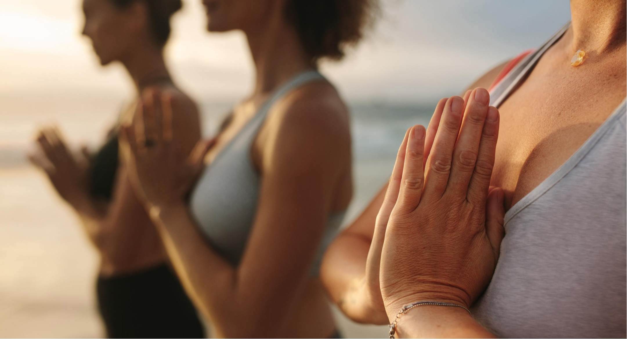 Image of a group of women doing yoga heart chakra pose, for stress relief.